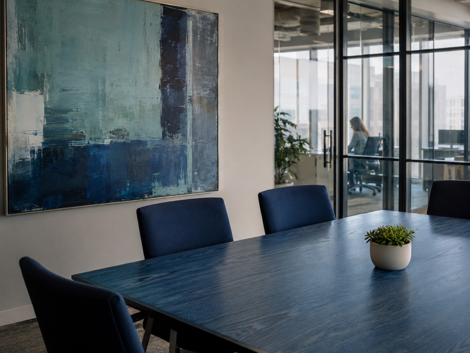 Private boardroom with navy chairs and large abstract blue artwork